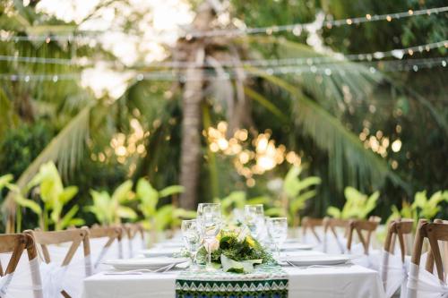a long table with glasses and flowers on it at Desa Di Bali Villas in Kerobokan