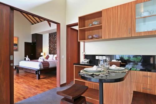 a living room with a bed and a dining room at Desa Di Bali Villas in Kerobokan