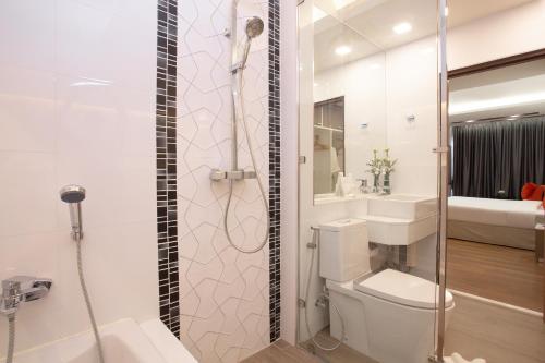 a bathroom with a shower and a toilet and a sink at Khum Phucome Hotel -SHA Extra Plus in Chiang Mai