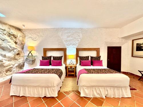 a hotel room with two beds with purple pillows at Molino de los Reyes in Totolac
