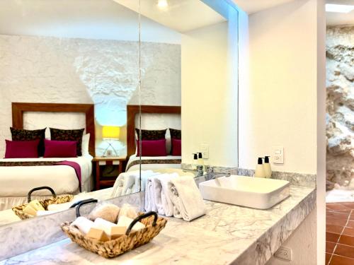 a bathroom with a sink and a bedroom with two beds at Molino de los Reyes in Totolac