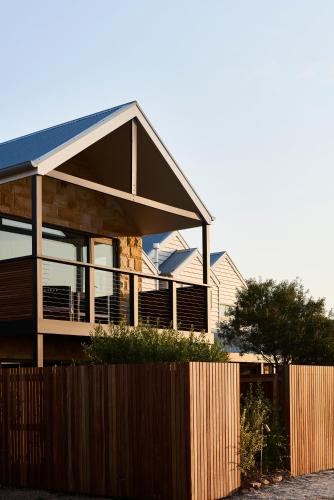 una casa con una valla de madera delante de ella en Lon Retreat, en Point Lonsdale