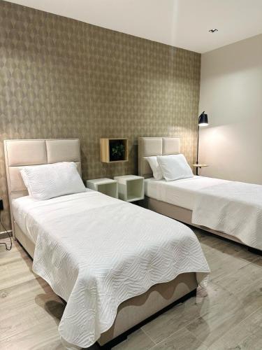a bedroom with two beds and a tv at VIDA, Casa Tua Suriname in Paramaribo