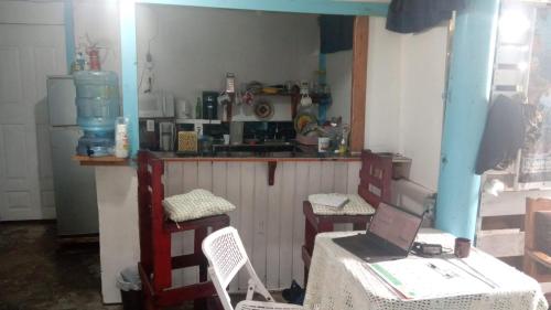 a kitchen with a table and two chairs and a laptop at Hotel Victoria s Beach House in Roatan