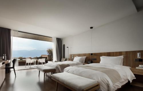 two beds in a hotel room with a view at Skyline Cloud Cliff Sea View Hotel in Dali