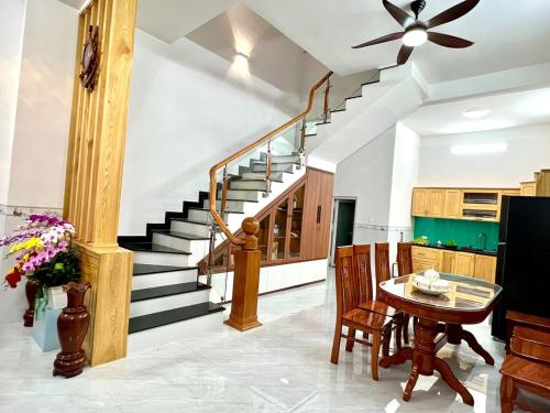 a living room with a staircase and a table and chairs at Villa 1985 in Buon Ma Thuot