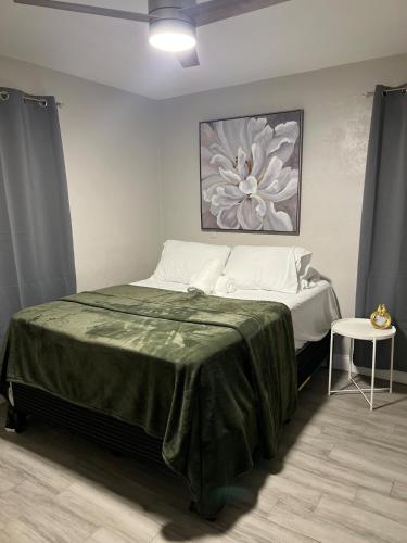 a bedroom with a bed with a green blanket at City and Stadium Sanctuary Vibes in Orlando