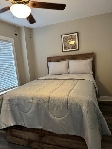 a bedroom with a large bed with a ceiling fan at Modern Comfort in Historic East Baltimore Stylish 3BR Row Home in Baltimore