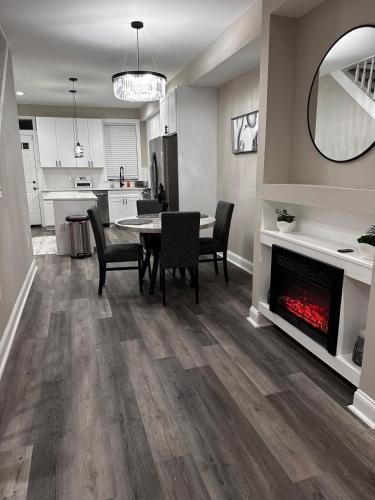 a living room with a table and chairs and a fireplace at Modern Comfort in Historic East Baltimore Stylish 3BR Row Home in Baltimore