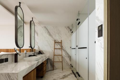 a bathroom with two sinks and two mirrors at Skyline Cloud Cliff Sea View Hotel in Dali