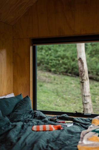 a bed in a room with a window at Off-Grid Cabin Tucked into Nature - Pet Friendly - Mahli in Dingadee