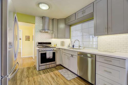Una cocina con gabinetes blancos y electrodomésticos de acero inoxidable. en Colors of Colorado Parks & Trails Dog-Friendly, en Fountain