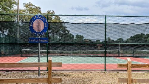 a tennis court with a sign on a fence at Dora's Haven Getaway-Cozy 1Bedroom with Boat or Camper Parking- Free in Mount Dora