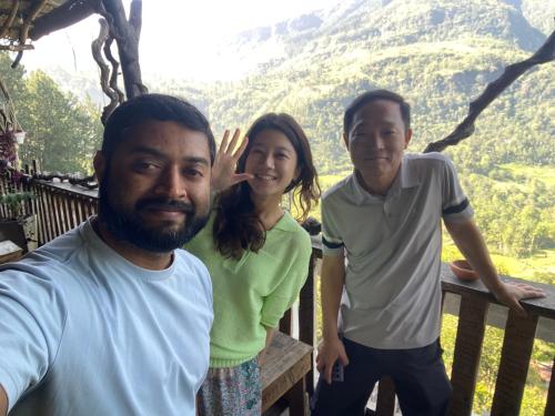 a woman and two men standing on a porch with a mountain at Sesatha lake Kandy in Kandy