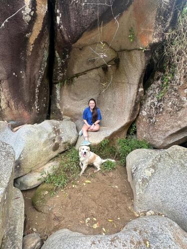 a woman sitting on a rock with a dog at HOSPEDAJE MARIN in Concepción