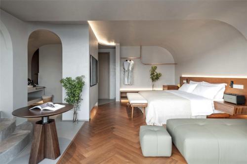 a hotel room with a bed and a table at Skyline Cloud Cliff Sea View Hotel in Dali