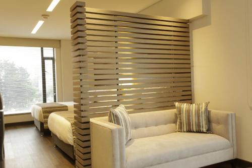 a living room with a couch and a large wooden wall at bs Rosales Hotel in Bogotá