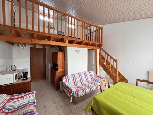 Cette chambre dispose d'un escalier, d'un lit et d'une table. dans l'établissement Maison au bourg de Saint-Mathurin, proche commerces, à 10km des plages des Sables d'Olonne, pour 2 pers. - FR-1-197-546, à Saint-Mathurin