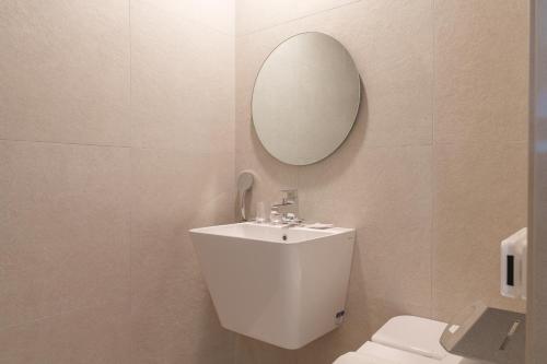 a white bathroom with a sink and a mirror at ibis Styles Ambassador Jeonju City Centre in Jeonju