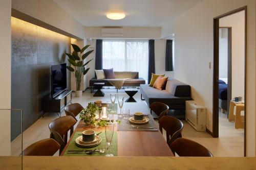 a living room with a dining table and a couch at Minn Kitahiroshima Station East in Nakanosawa