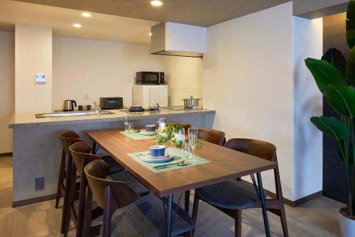 a kitchen and dining room with a wooden table and chairs at Minn Kitahiroshima Station East in Nakanosawa