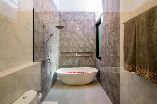 a bathroom with a bath tub and a toilet at Sanur Bali Villas by Premier Hospitality Asia in Sanur