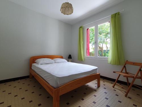 a bedroom with a bed and a window and a chair at Maison spacieuse 6 pers. près plage avec jardin - FR-1-476-204 in La Faute-sur-Mer