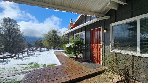 a house with a red door and a brick walkway at Rustic Yosemite Cottage-King Suite-Mountain Views in Oakhurst