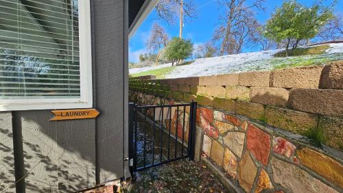a brick wall with a gate on a house at Rustic Yosemite Cottage-King Suite-Mountain Views in Oakhurst