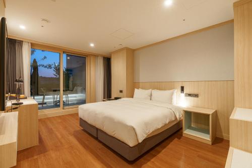 a bedroom with a large bed and a large window at ibis Styles Ambassador Jeonju City Centre in Jeonju