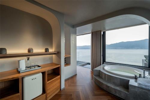 a bathroom with a tub and a large window at Skyline Cloud Cliff Sea View Hotel in Dali