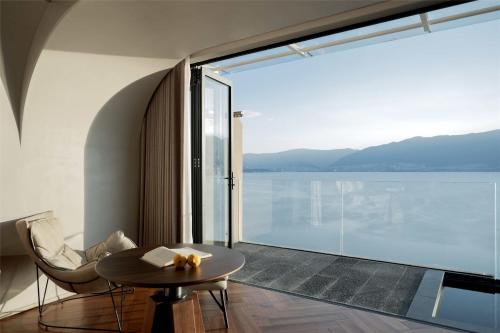 a room with a table and a view of the water at Skyline Cloud Cliff Sea View Hotel in Dali