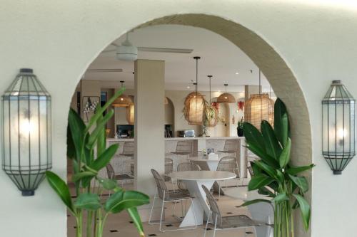 an archway in a restaurant with tables and chairs at Aster Apartment Bali in Canggu