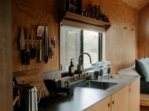 cocina con fregadero, ventana y encimera en Secluded & Pet Friendly Cabin Deep in Nature - Zerya, en Coleyville