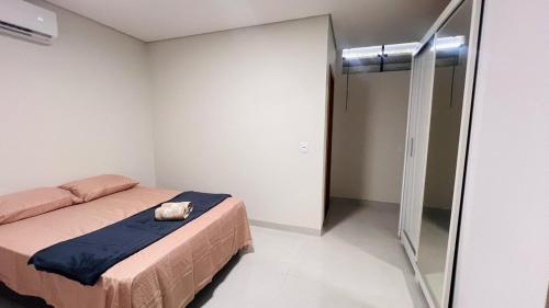 a small bedroom with a bed and a glass door at Ap bem localizado e aconchegante in Sinop