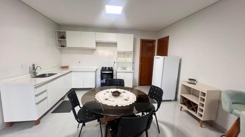 a kitchen with a table and chairs and a refrigerator at Ap bem localizado e aconchegante in Sinop