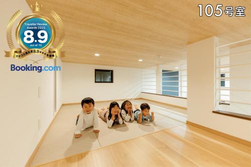 three children laying on the floor in a room at YOUR ROOM 熊本駅 in Kumamoto