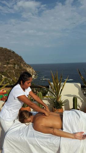 a womanolithing a naked woman on a bed at Casa Roni by Xeno - 5 Bedroom Luxury Villa with Ocean View in Playa Estacahuite
