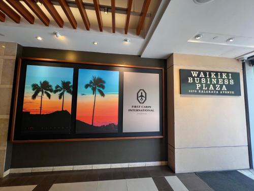 a lobby of a building with a sunset in the window at First Cabin International Hawaii in Honolulu