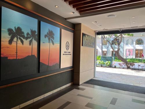 a hallway with a large window with palm trees at First Cabin International Hawaii in Honolulu