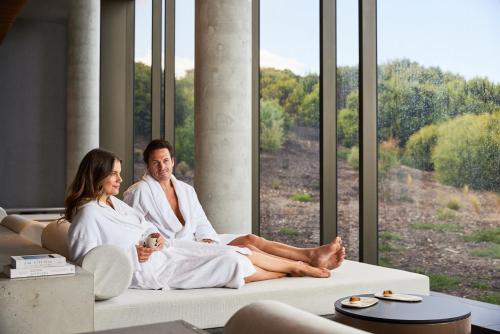 a man and woman sitting on a couch in front of a window at The Sanctuary at Alba Thermal Springs & Spa in Fingal