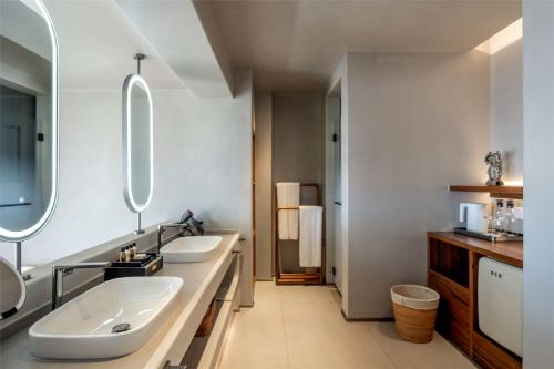 a bathroom with two sinks and two mirrors at Skyline Cloud Cliff Sea View Hotel in Dali
