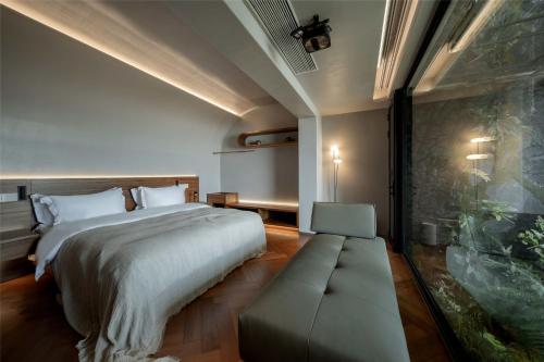 a bedroom with a large bed and a couch at Skyline Cloud Cliff Sea View Hotel in Dali