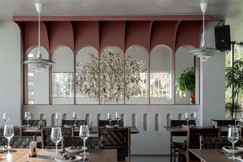a dining room with tables and chairs and a chandelier at Skyline Cloud Cliff Sea View Hotel in Dali