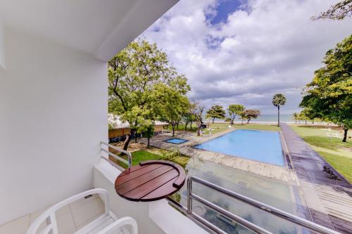 a balcony with a view of a swimming pool at Trinco Blu by Cinnamon in Trincomalee