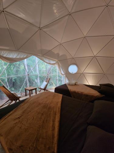 a room with a tent with a bed and a table at Ku kuk Glamping in Chemuyil