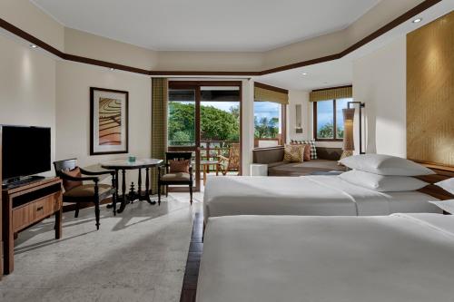 a hotel room with two beds and a television at Grand Hyatt Bali in Nusa Dua