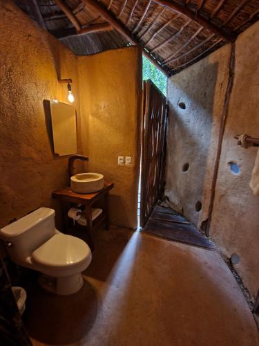 a bathroom with a toilet and a sink at Ku kuk Glamping in Chemuyil