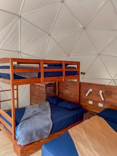 a room with two bunk beds in a yurt at Ku kuk Glamping in Chemuyil