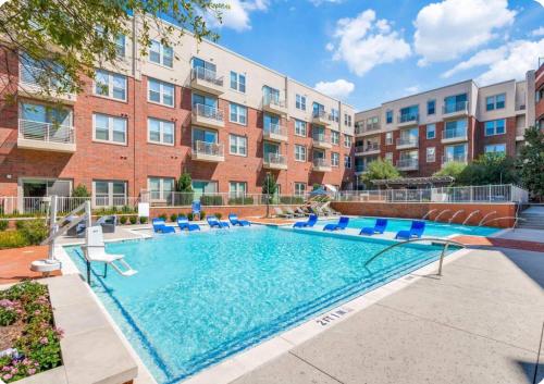 フリスコにあるStylish 1BR Retreat with Pool & Gymの椅子と建物のあるプール
